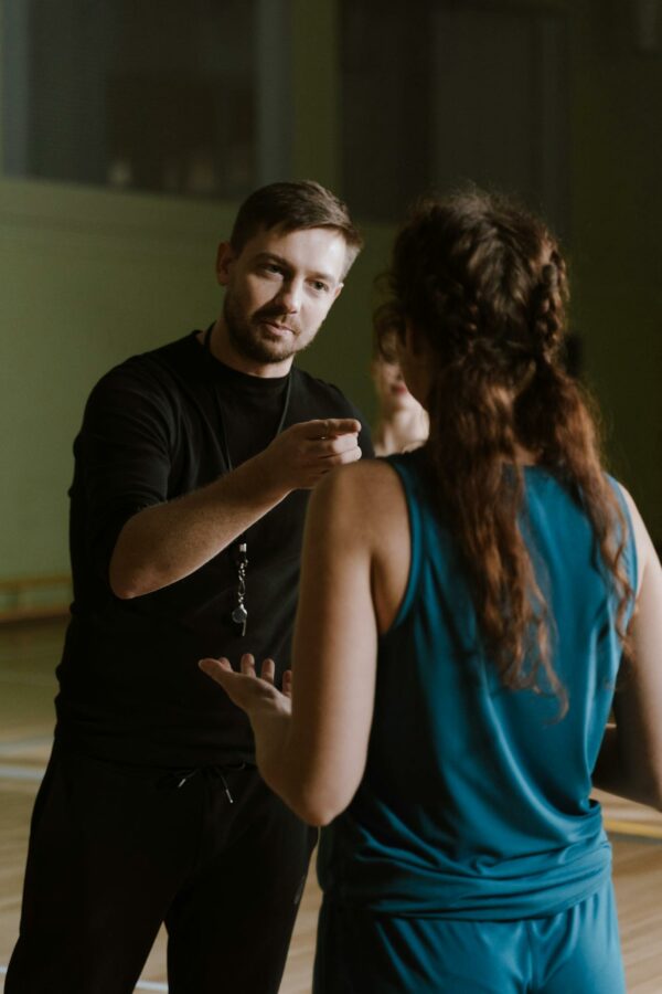 A coach motivates an athlete indoors, emphasizing discipline and focus.