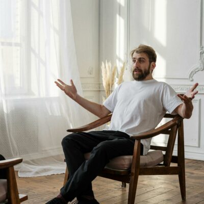 A therapist discusses with a patient in a bright, sunlit room for a mental health session.