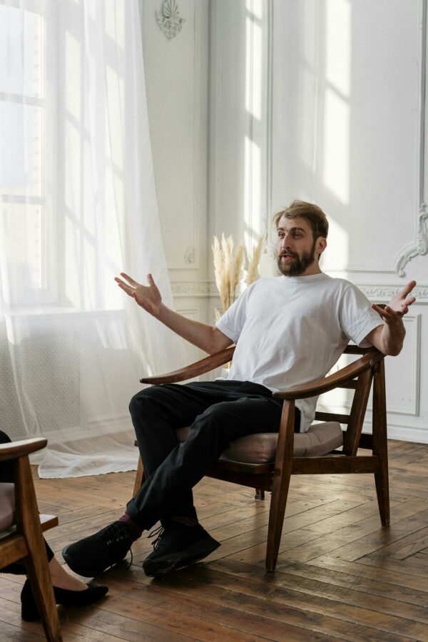 A therapist discusses with a patient in a bright, sunlit room for a mental health session.