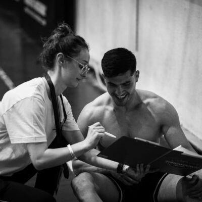 Trainer and client discussing fitness plan in gym. Black and white photo capturing a coaching session.